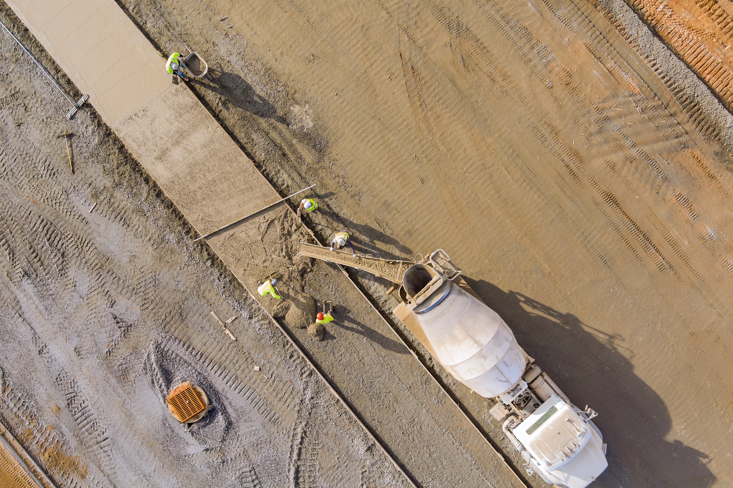 Betonowoz i ekipa budowlana podczas betonowania płyty — dostawa betonu towarowego na budowę